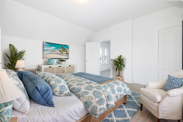 bedroom featuring vaulted ceiling and wood finished floors