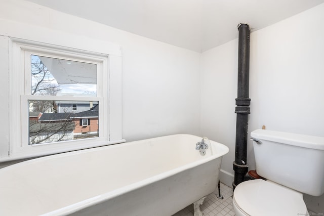 bathroom with a freestanding tub, toilet, and a wealth of natural light