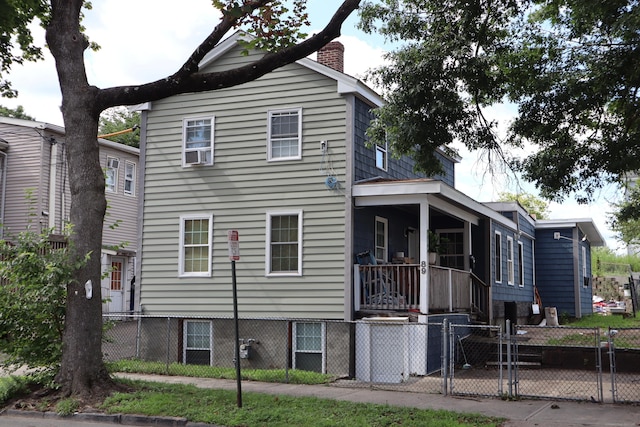 view of front of home with a fenced front yard, a gate, and a chimney