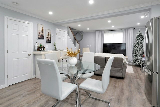 dining space featuring light wood-type flooring, stairway, crown molding, and recessed lighting