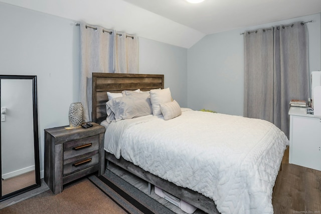 bedroom with dark wood-type flooring and vaulted ceiling