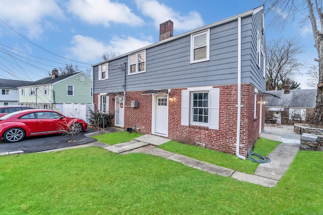 view of front of property featuring a chimney, a residential view, a front lawn, and brick siding