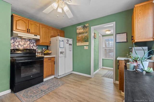 kitchen featuring a ceiling fan, light wood-style flooring, under cabinet range hood, black range with electric cooktop, and white fridge with ice dispenser