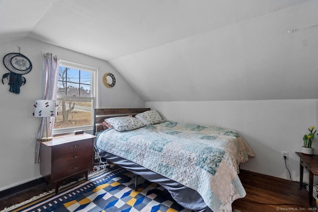 bedroom featuring lofted ceiling and wood finished floors