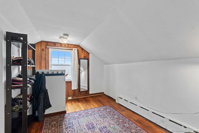 home office with lofted ceiling, baseboard heating, and wood finished floors