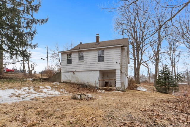 back of house with a chimney