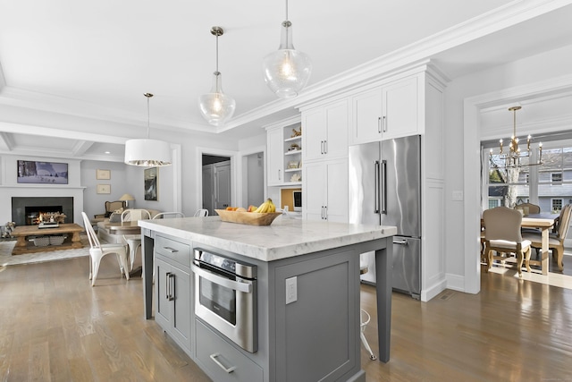 kitchen featuring gray cabinetry, white cabinets, a lit fireplace, appliances with stainless steel finishes, and dark wood finished floors