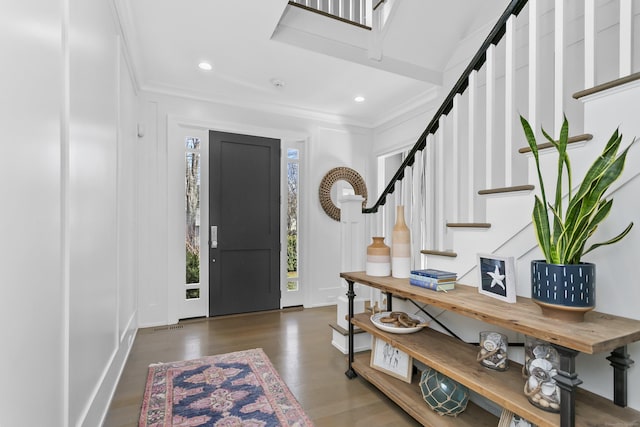 foyer entrance featuring ornamental molding, stairway, wood finished floors, and recessed lighting