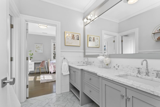 ensuite bathroom featuring crown molding, double vanity, a sink, and ensuite bathroom