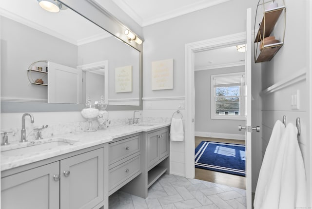 full bath with crown molding, a sink, baseboards, and double vanity