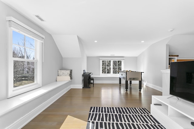 interior space with a wealth of natural light, visible vents, lofted ceiling, and wood finished floors