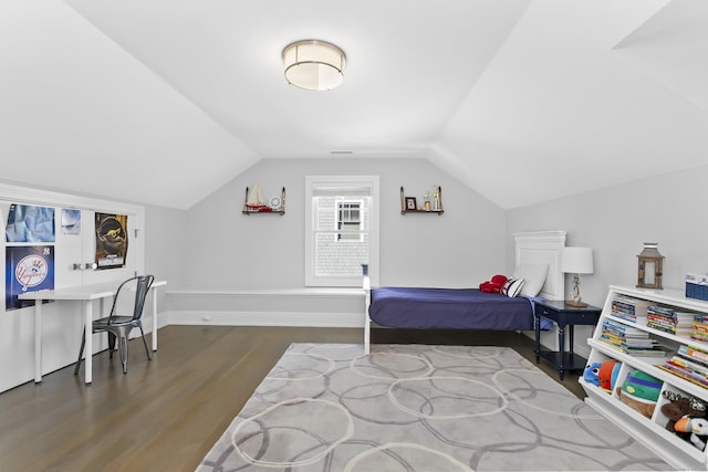 bedroom with vaulted ceiling, wood finished floors, and baseboards