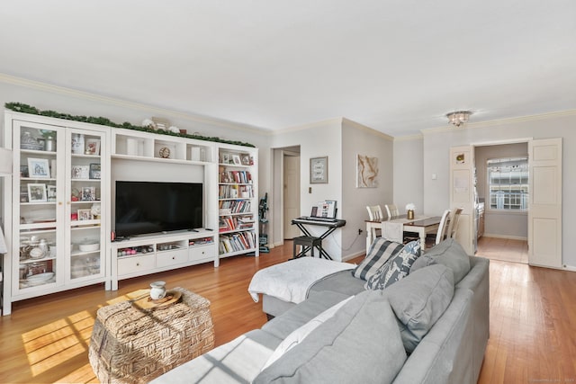 living room with crown molding, baseboards, and wood finished floors