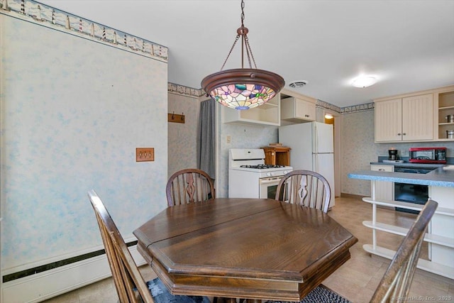 dining area with baseboard heating, wallpapered walls, visible vents, and baseboards