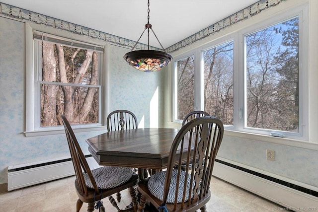 dining area with a healthy amount of sunlight, a baseboard heating unit, and wallpapered walls