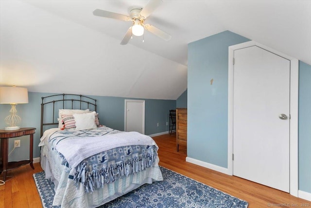 bedroom featuring baseboards, wood finished floors, a ceiling fan, and vaulted ceiling