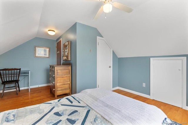 bedroom featuring lofted ceiling, ceiling fan, wood finished floors, and baseboards