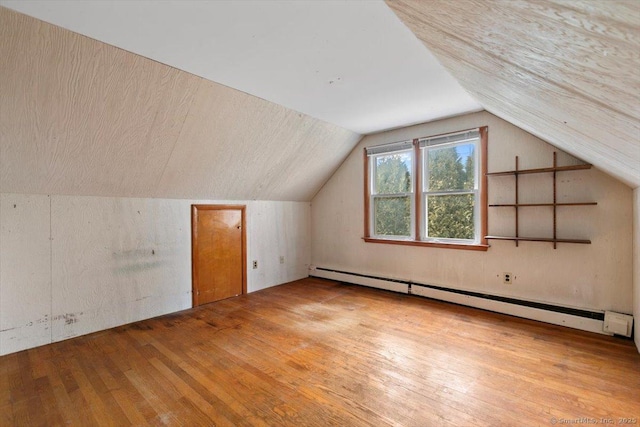 bonus room featuring a baseboard heating unit, hardwood / wood-style floors, and vaulted ceiling