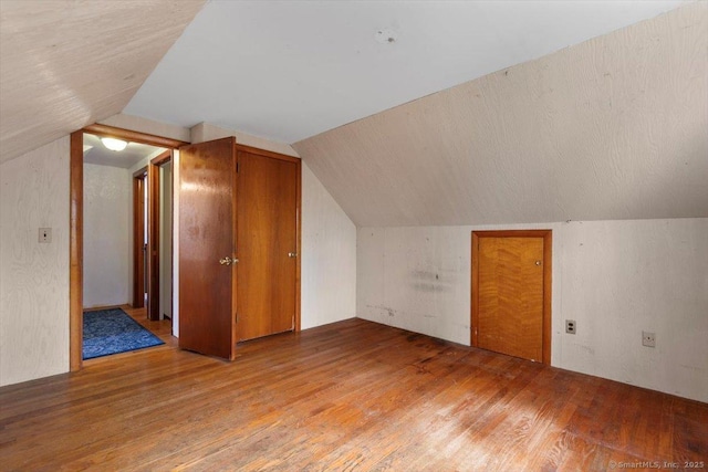 additional living space featuring lofted ceiling and light wood-style flooring