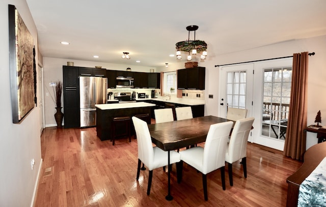 dining room featuring baseboards, light wood finished floors, and recessed lighting