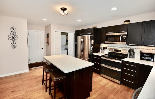 kitchen featuring appliances with stainless steel finishes, light wood-type flooring, and light countertops