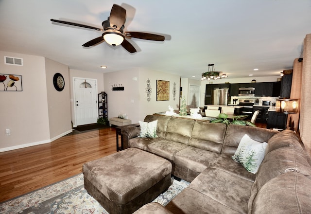 living area featuring baseboards, visible vents, a ceiling fan, wood finished floors, and recessed lighting