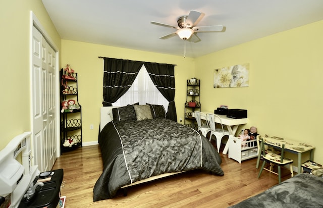 bedroom with a ceiling fan, a closet, baseboards, and wood finished floors