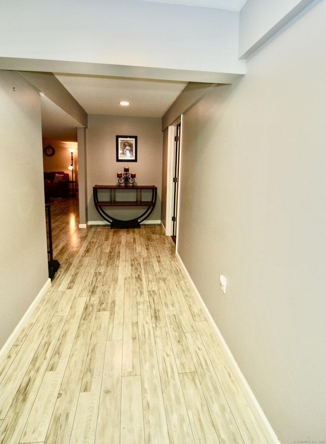 hallway featuring baseboards and wood finished floors