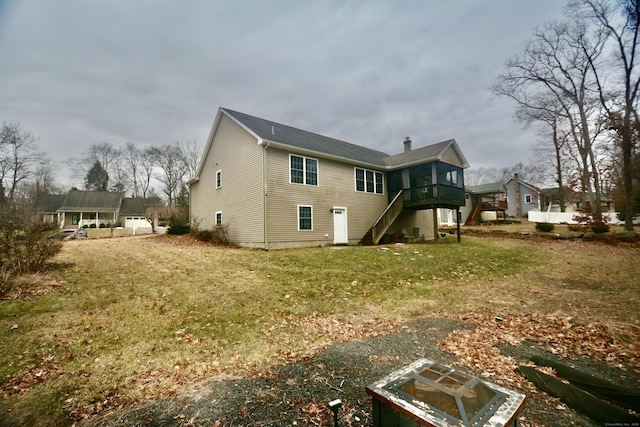 back of house with a chimney, a yard, and stairway