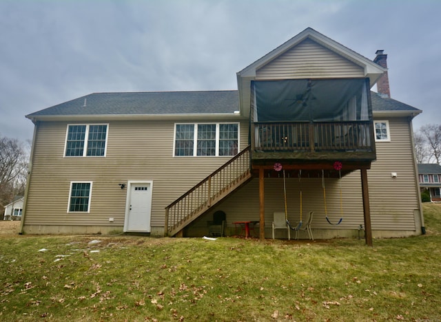 rear view of house featuring a lawn, a deck, and stairs