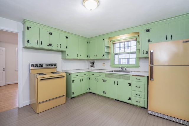 kitchen featuring light wood-style flooring, white appliances, a sink, light countertops, and open shelves