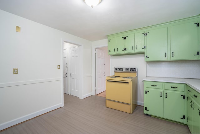 kitchen featuring green cabinetry, light countertops, electric range, and light wood finished floors