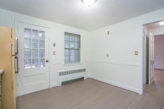 interior space with baseboards, radiator heating unit, and wood finished floors