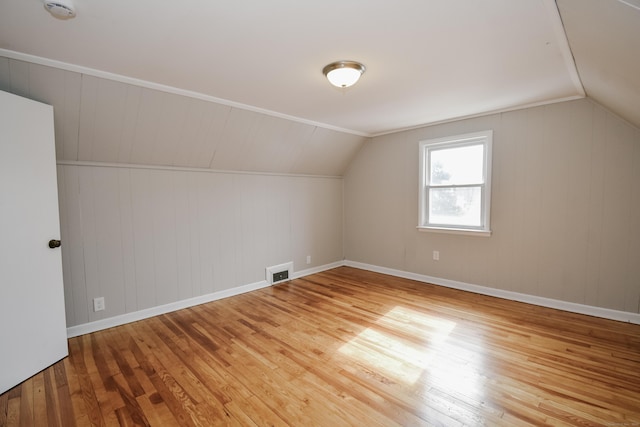 additional living space featuring lofted ceiling, baseboards, visible vents, and hardwood / wood-style floors