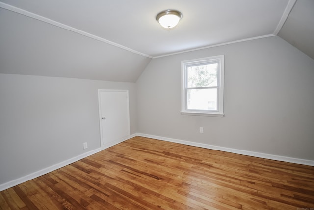 bonus room with baseboards, vaulted ceiling, and wood finished floors