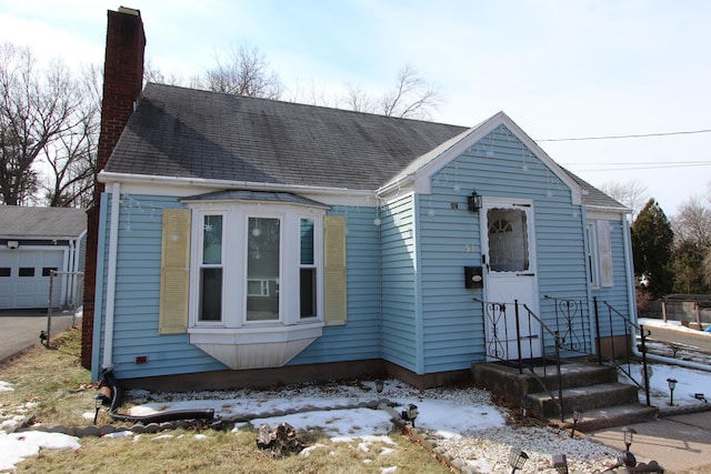 view of front of house featuring an outbuilding and a chimney