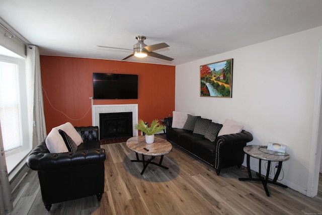 living room with ceiling fan, a fireplace, and wood finished floors