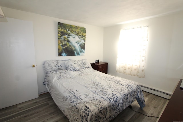 bedroom with baseboard heating and wood finished floors