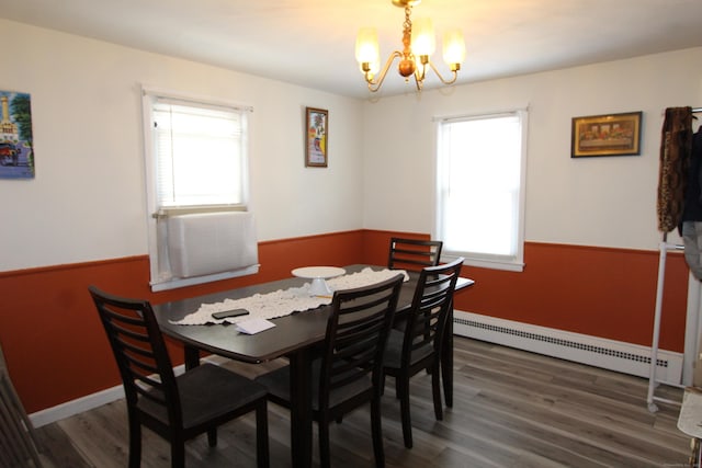 dining area with an inviting chandelier, wainscoting, baseboard heating, and wood finished floors