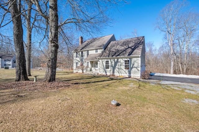 view of front of house with a chimney and a front lawn