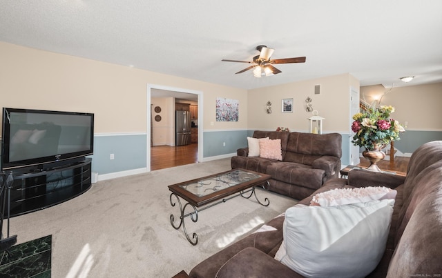 living room featuring ceiling fan, carpet, visible vents, and baseboards