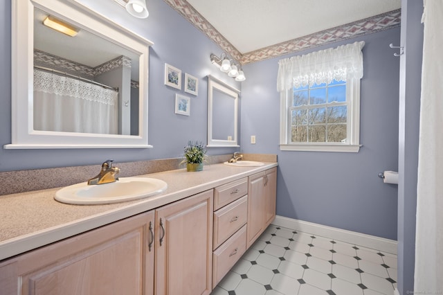 bathroom with a sink, baseboards, and double vanity