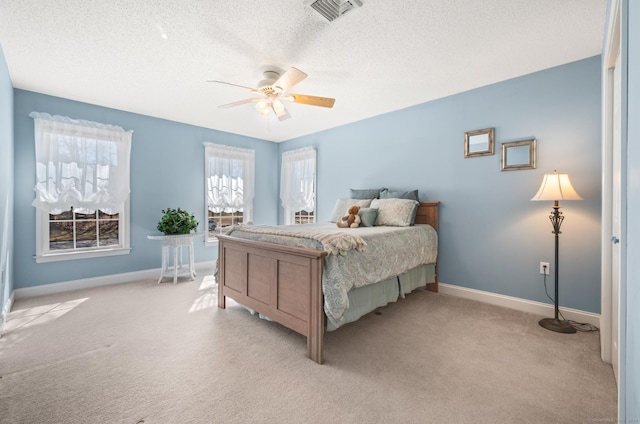 bedroom featuring baseboards, a textured ceiling, visible vents, and light colored carpet