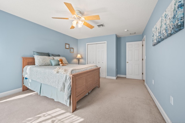 bedroom with a closet, visible vents, a ceiling fan, light carpet, and baseboards