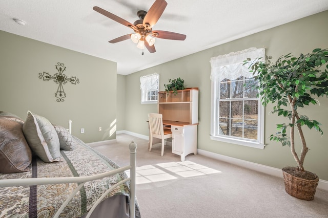 bedroom featuring a ceiling fan, light colored carpet, and baseboards