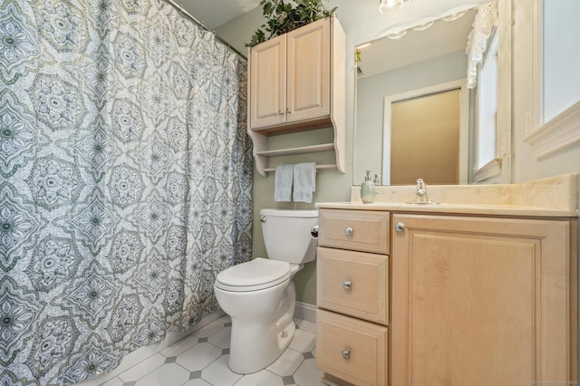 full bath with vanity, toilet, and baseboards