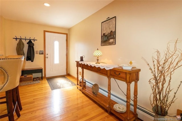 entryway with a baseboard radiator, baseboards, light wood finished floors, and recessed lighting