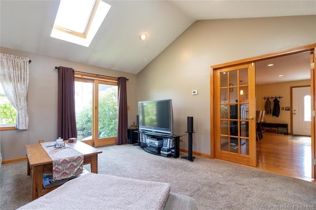 carpeted living room featuring vaulted ceiling with skylight, recessed lighting, and baseboards