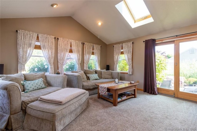 living room with vaulted ceiling with skylight and carpet flooring