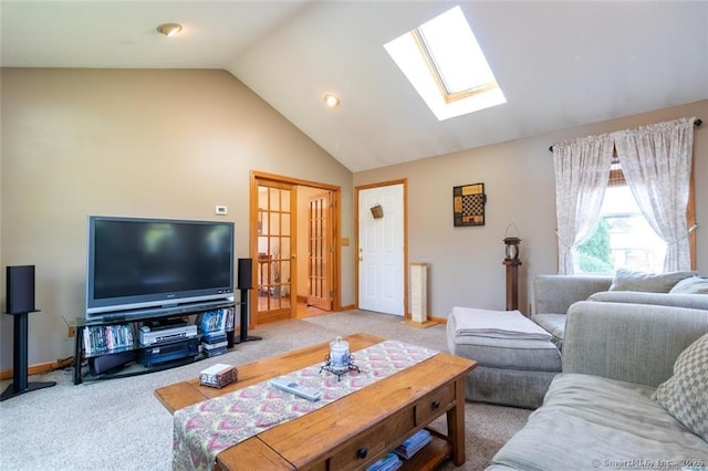 living area with carpet floors, vaulted ceiling with skylight, and baseboards